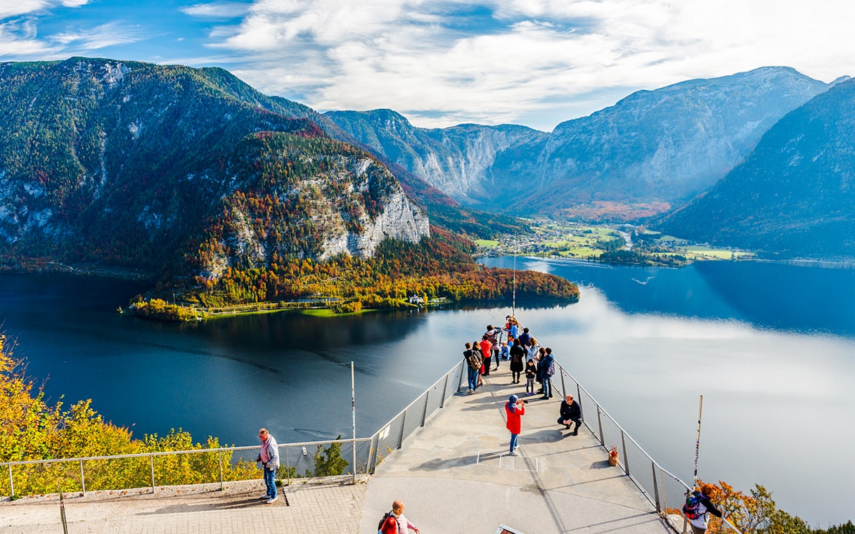 Visitors on the Skywalk lookout bridge overlooking Hallstatt, Austria's lake and mountains.