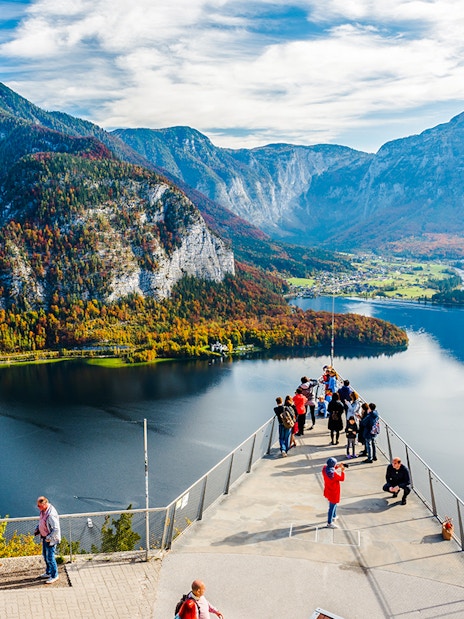 Visitors on the Skywalk lookout bridge overlooking Hallstatt, Austria's lake and mountains.