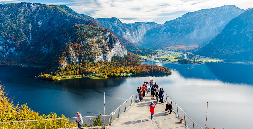 Visitors on the Skywalk lookout bridge overlooking Hallstatt, Austria's lake and mountains.