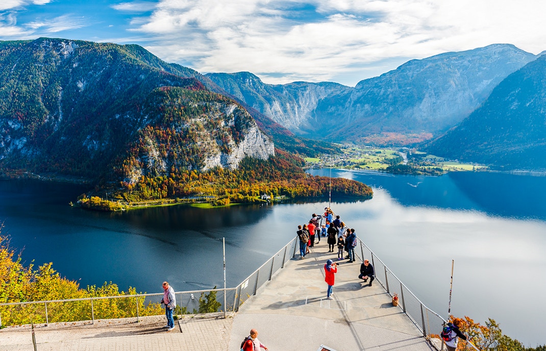 Visitors on the Skywalk lookout bridge overlooking Hallstatt, Austria's lake and mountains.