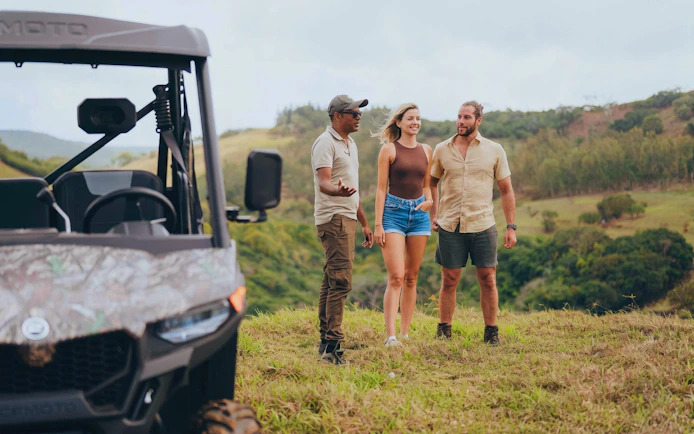 Group enjoying Bel Ombre buggy tour with scenic landscape in background.