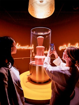 Tourists photographing chocolate fountain at Chocoversum, Hamburg.