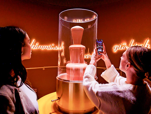 Tourists photographing chocolate fountain at Chocoversum, Hamburg.