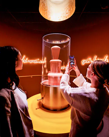 Tourists photographing chocolate fountain at Chocoversum, Hamburg.