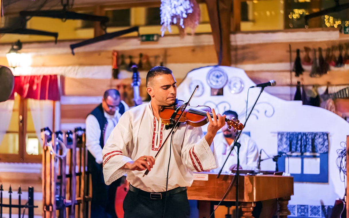 Musician playing violin at Prague folklore dinner show.
