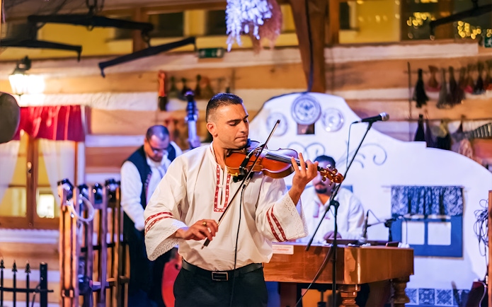 Musician playing violin at Prague folklore dinner show.