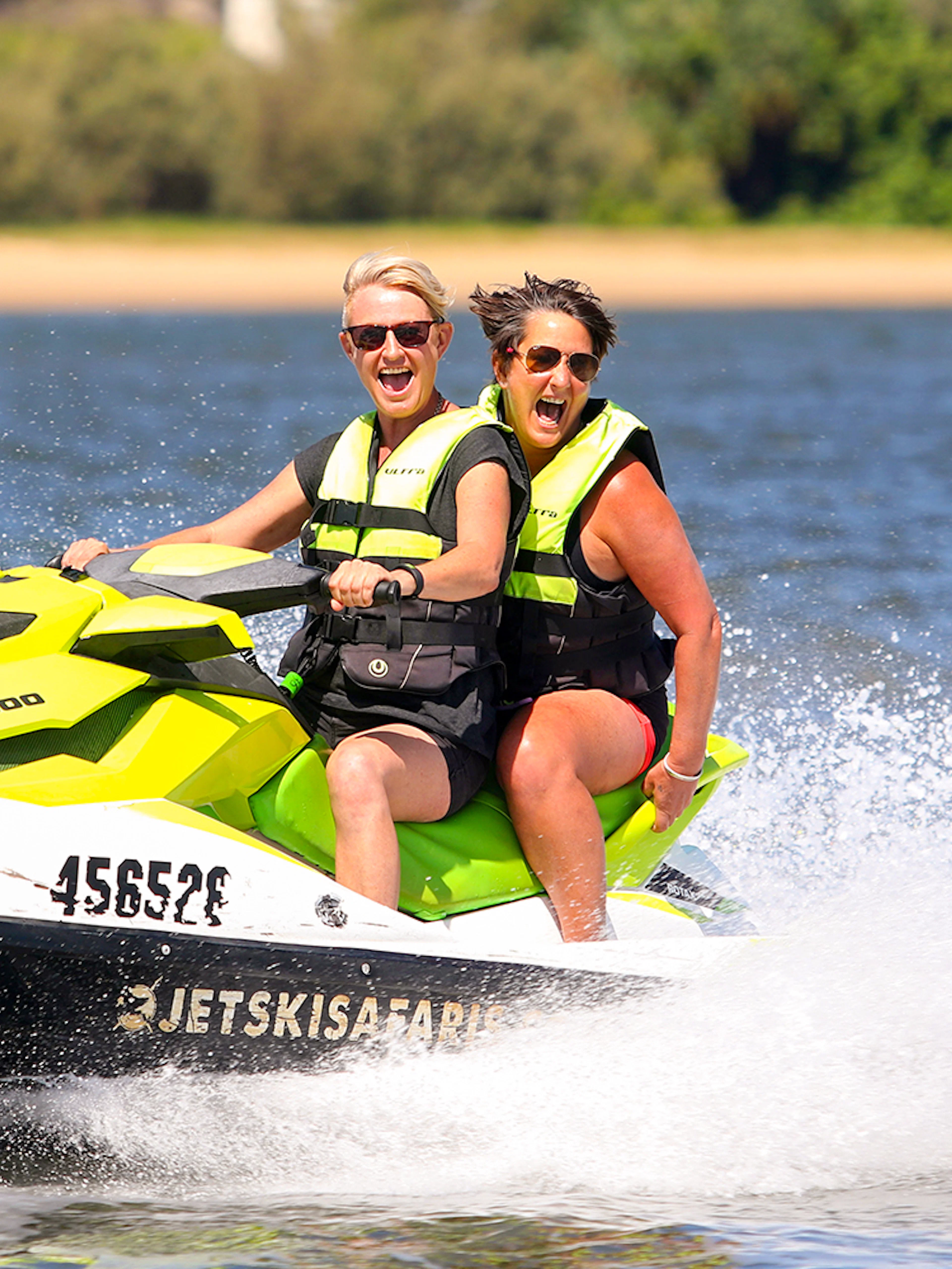 Two people enjoying a jet ski ride on open water, part of a Jet Ski & Parasail Experience.