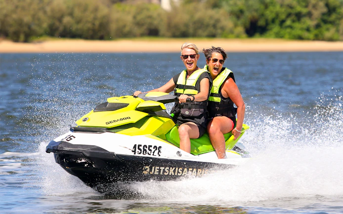 Two people enjoying a jet ski ride on open water, part of a Jet Ski & Parasail Experience.