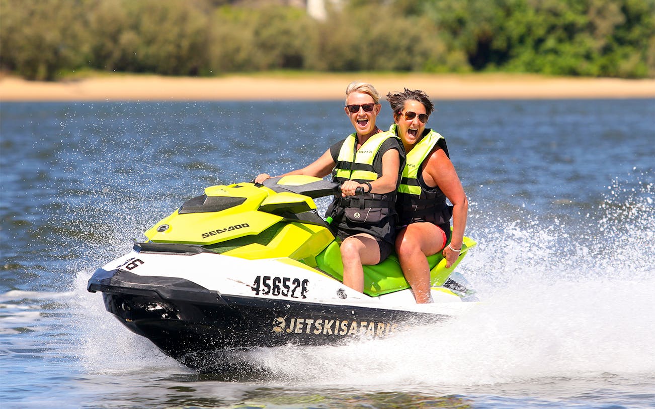 Two people enjoying a jet ski ride on open water, part of a Jet Ski & Parasail Experience.