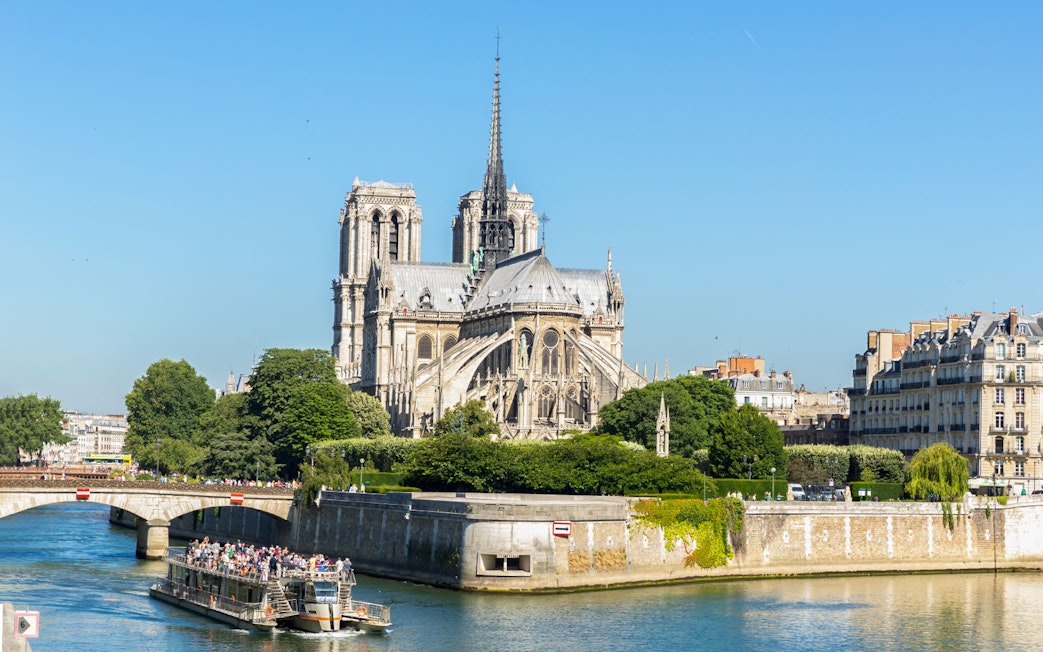 Cruise ship on Seine River passing Notre Dame Cathedral, Paris.