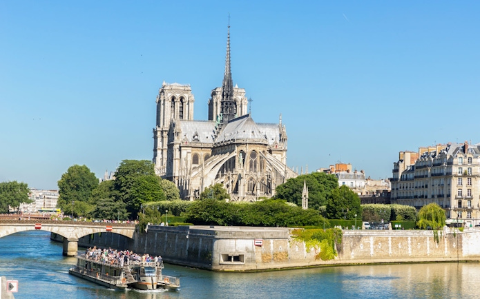 Cruise ship on Seine River passing Notre Dame Cathedral, Paris.