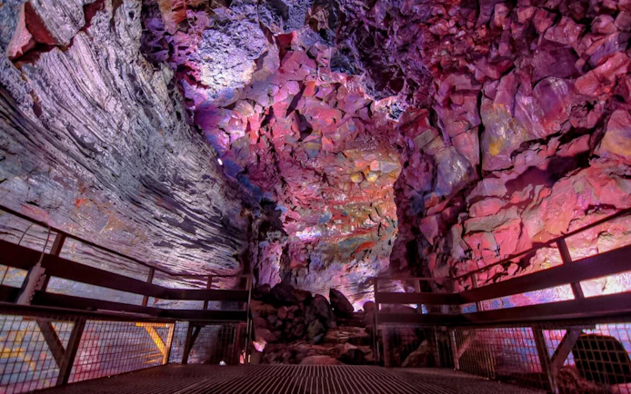 Inside view of Raufarhólshellir Lava Tunnel with colorful rock formations.