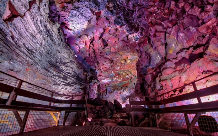 Inside view of Raufarhólshellir Lava Tunnel with colorful rock formations.