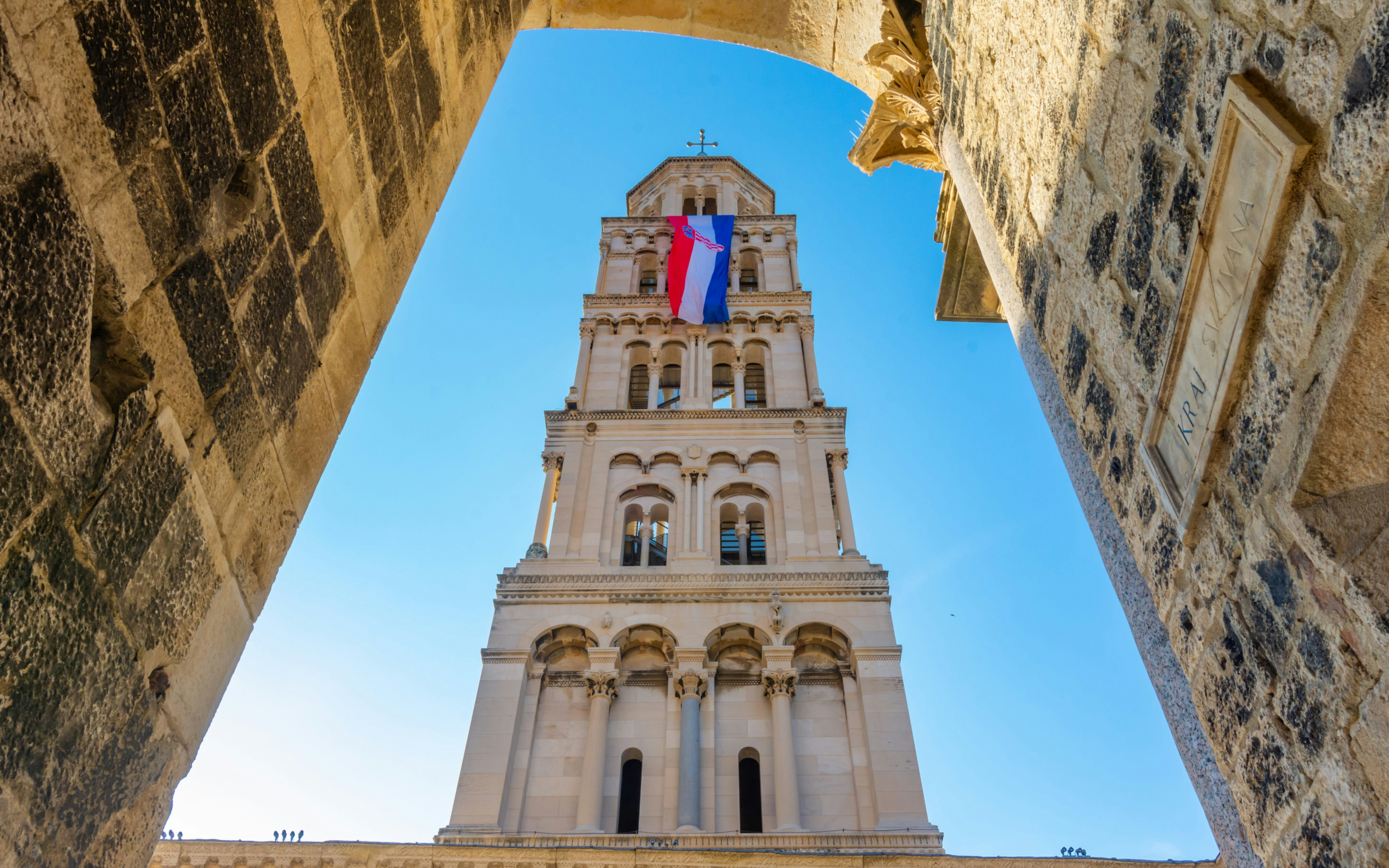 Cathedral of Saint Domnius bell tower with Croatian flag in Split, Croatia.