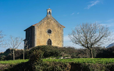 Santa Catalina hermitage surrounded by trees in Mundaka, Vizcaya, Spain.