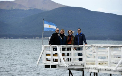 Group on a pier with Argentine flag at Lago Fagnano, Ushuaia, Argentina.