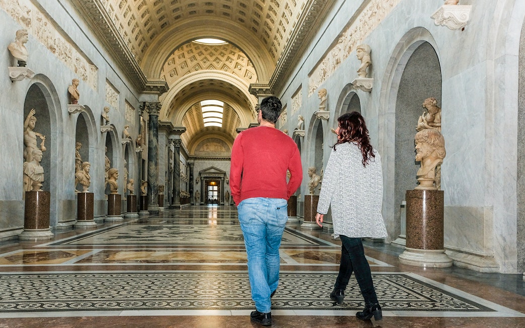Tour group walking through Braccio Nuovo, Vatican Museums, Rome.