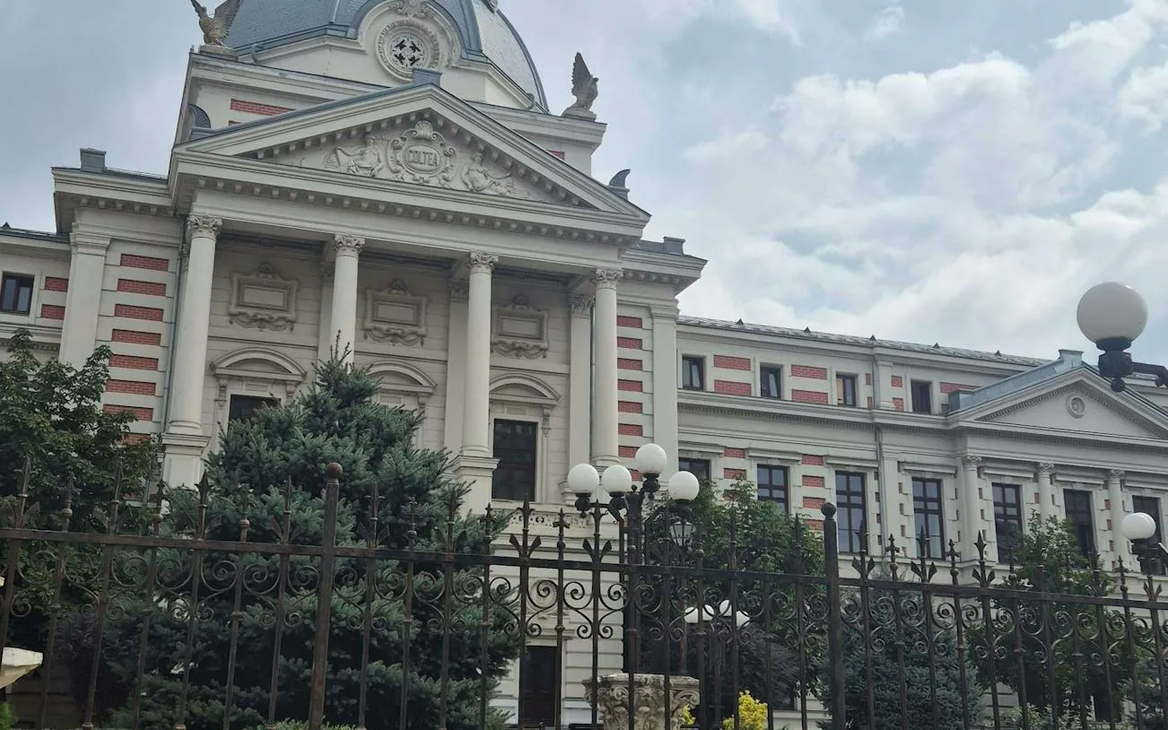 Neoclassical building with columns in Bucharest, part of The Vanishing Pharmacist city exploration game.