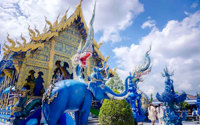 Blue Temple (Wat Rong Sua Ten) with intricate blue and gold designs and mythical sculptures in Chiang Rai, Thailand.