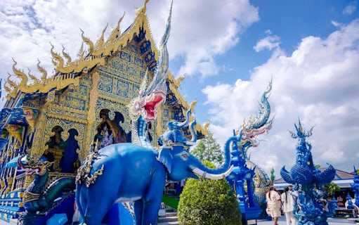 Blue Temple (Wat Rong Sua Ten) with intricate blue and gold designs and mythical sculptures in Chiang Rai, Thailand.
