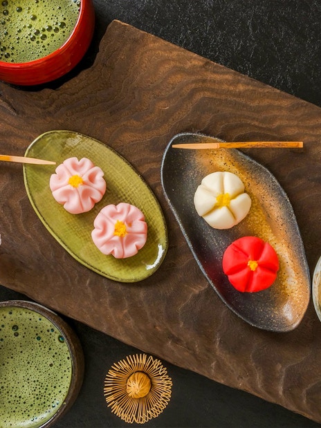 Matcha tea with traditional Japanese wagashi sweets and cherry blossoms.