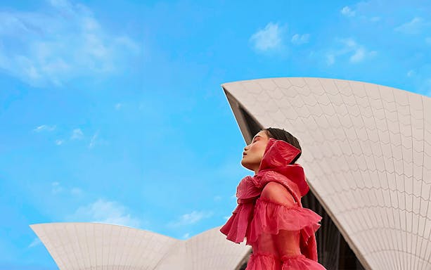 Chorus! Show performer in red dress at Sydney Opera House.