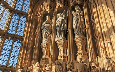 Statues inside Westminster Abbey, London, with intricate carvings and stained glass windows.