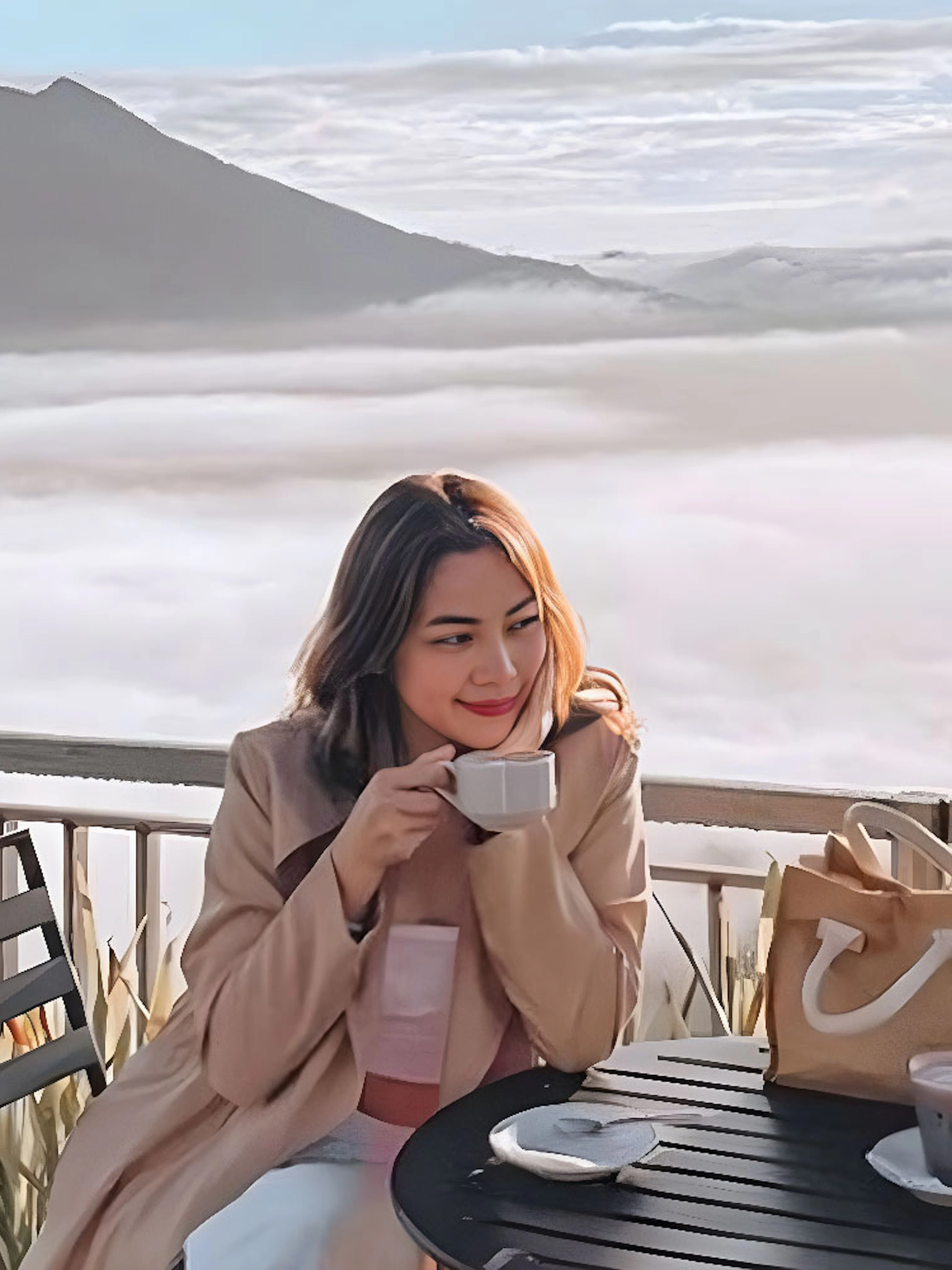 Woman enjoying coffee with a view of Mount Batur during Kintamani sunrise tour.