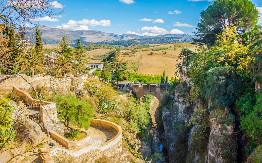 Puente Viejo bridge over El Tajo gorge in Ronda, Spain, with surrounding landscape.