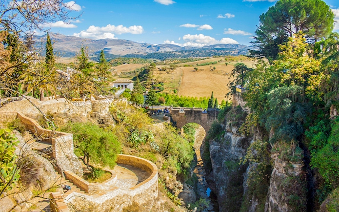 Puente Viejo bridge over El Tajo gorge in Ronda, Spain, with surrounding landscape.