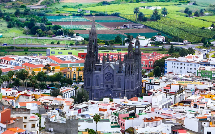 Church of San Juan Bautista in Arucas, Gran Canaria, surrounded by colorful town buildings.