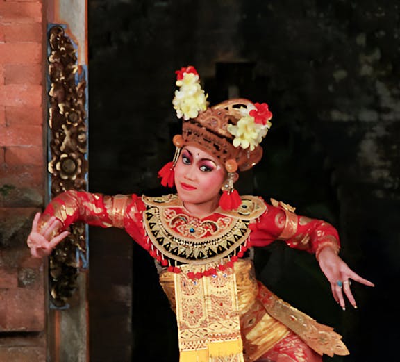 Balinese dancer in traditional costume performing at a temple in Bali, Indonesia.