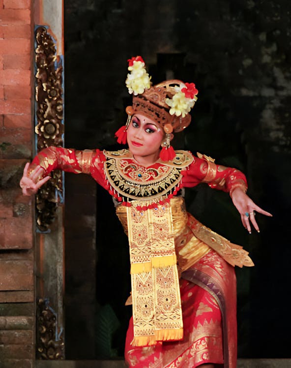 Balinese dancer in traditional costume performing at a temple in Bali, Indonesia.