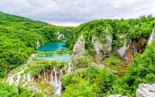 Plitvice Lakes National Park with cascading waterfalls and lush greenery.