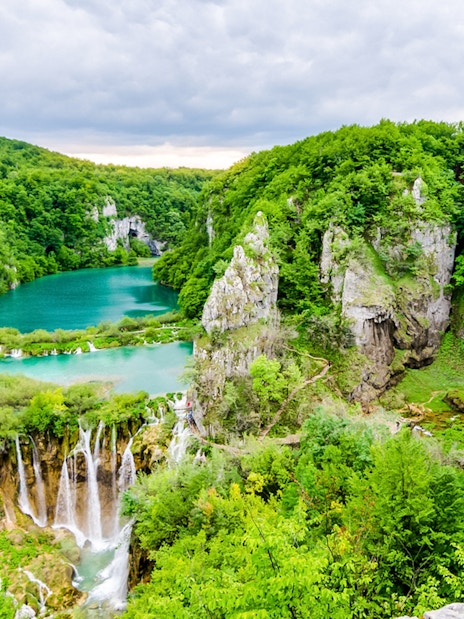 Plitvice Lakes National Park with cascading waterfalls and lush greenery.