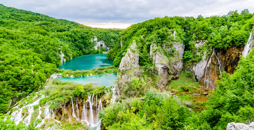 Plitvice Lakes National Park with cascading waterfalls and lush greenery.