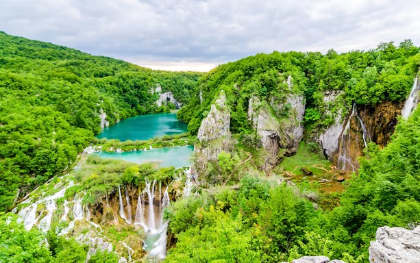 Plitvice Lakes National Park with cascading waterfalls and lush greenery.