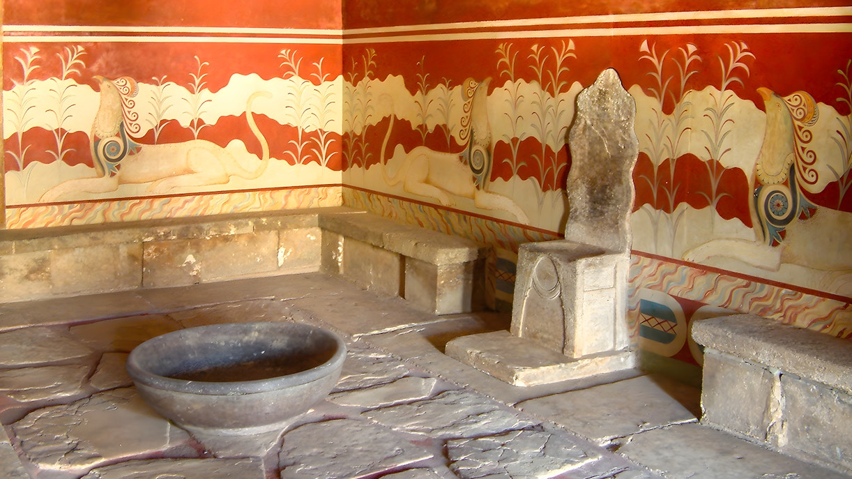 Throne room at Knossos Palace, featuring ancient stone seat and frescoes, Crete, Greece.