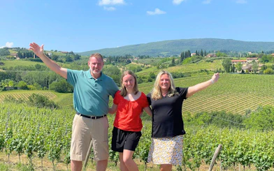 Family enjoying Tuscan vineyard view on food and wine tour near San Gimignano.