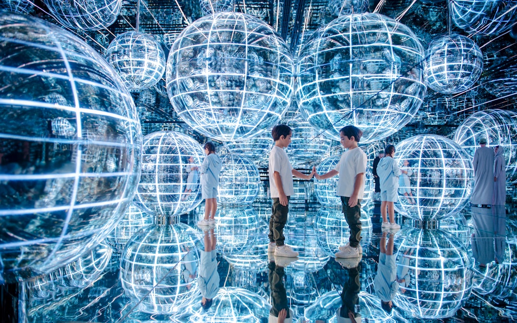 Kids interacting with glowing spheres in Luna zone, AYA universe, Dubai.