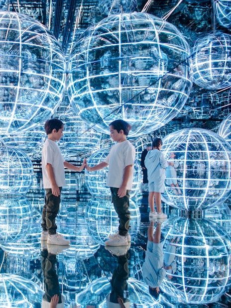 Kids interacting with glowing spheres in Luna zone, AYA universe, Dubai.