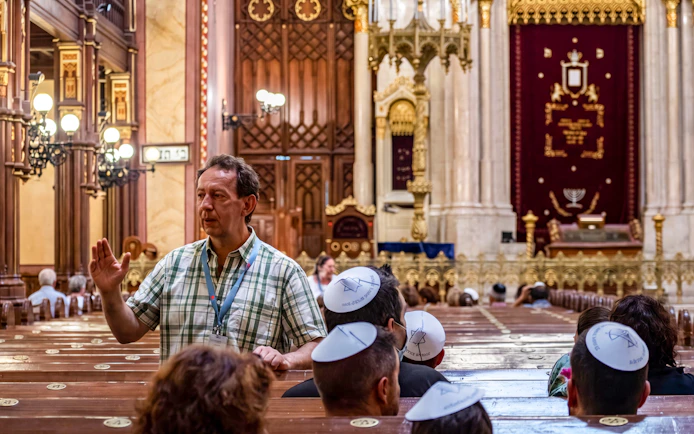 Guide leading a tour inside the Great Synagogue, highlighting architectural details.