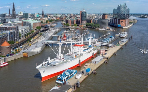 Hamburg harbor view with Elbphilharmonie and Cap San Diego ship, showcasing city attractions.