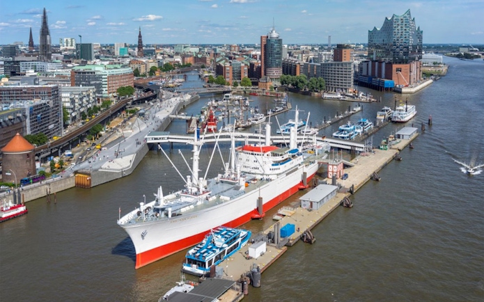Hamburg harbor view with Elbphilharmonie and Cap San Diego ship, showcasing city attractions.