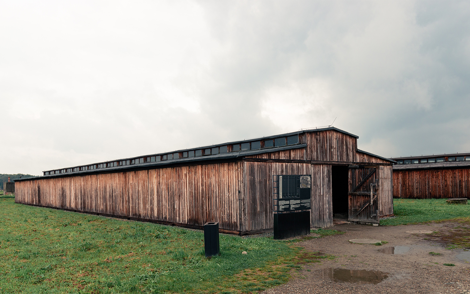 Stutthof Concentration Camp entrance with barbed wire fence and watchtower in Poland.