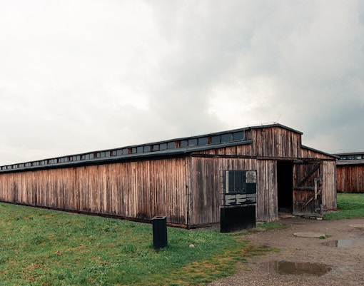 Stutthof Concentration Camp entrance with barbed wire fence and watchtower in Poland.