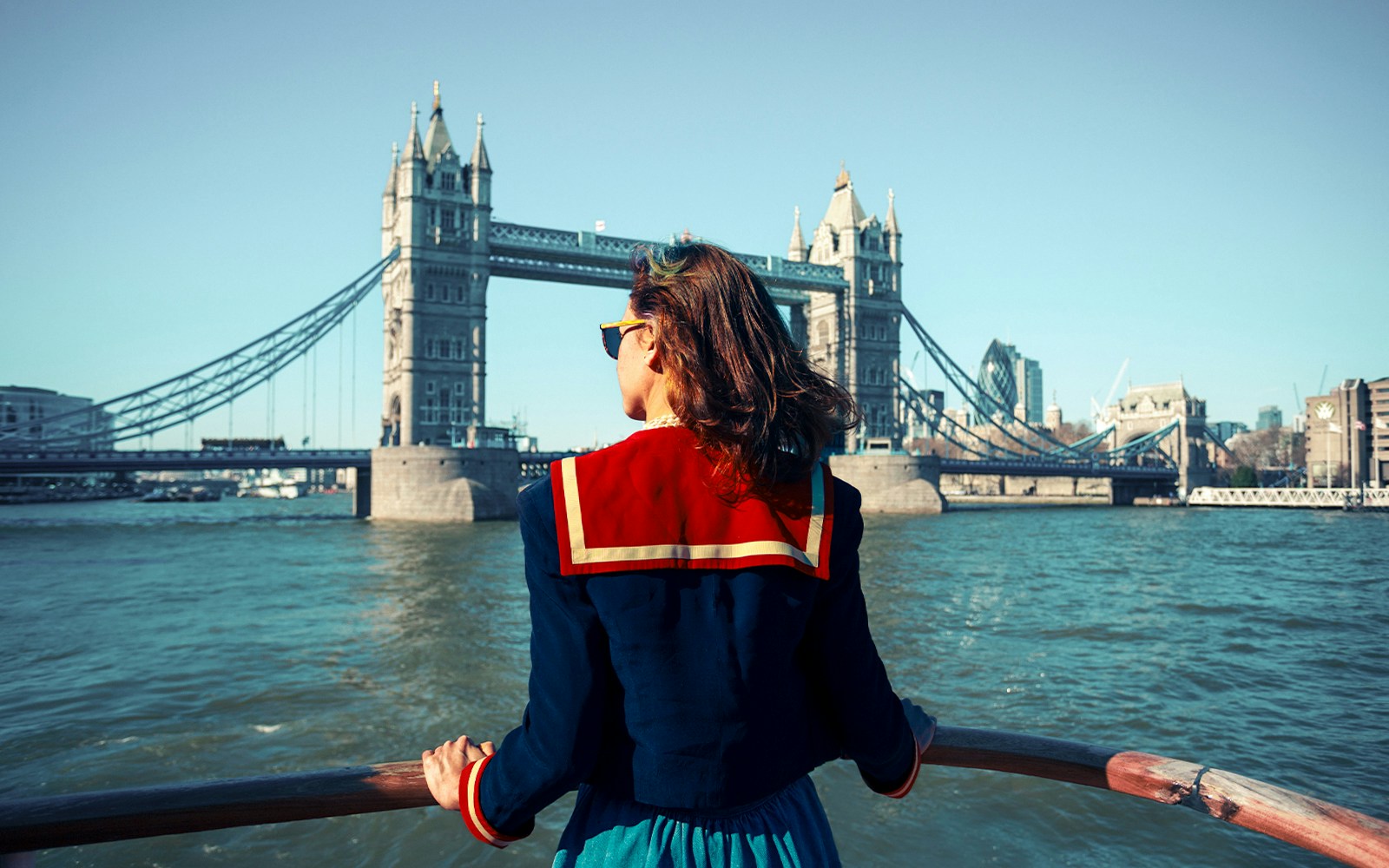 Young woman on a boat viewing Tower Bridge, London.