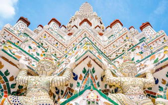 Wat Arun temple intricate facade with colorful guardian statues, Bangkok.