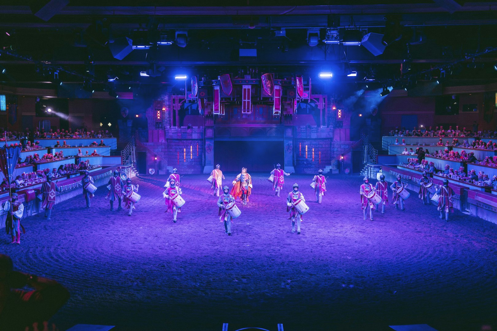 Drummers and performers in medieval attire at Tournament of Kings show in Las Vegas arena.