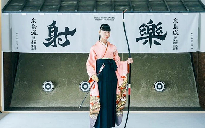 Japanese archer in traditional attire at Hiroshima Castle Sharaku archery range.